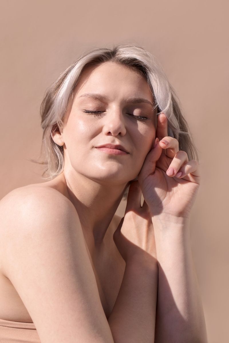 Mujer con ojos cerrados en momento de conexión interior como parte del bienestar femenino en Ellas en Armonía