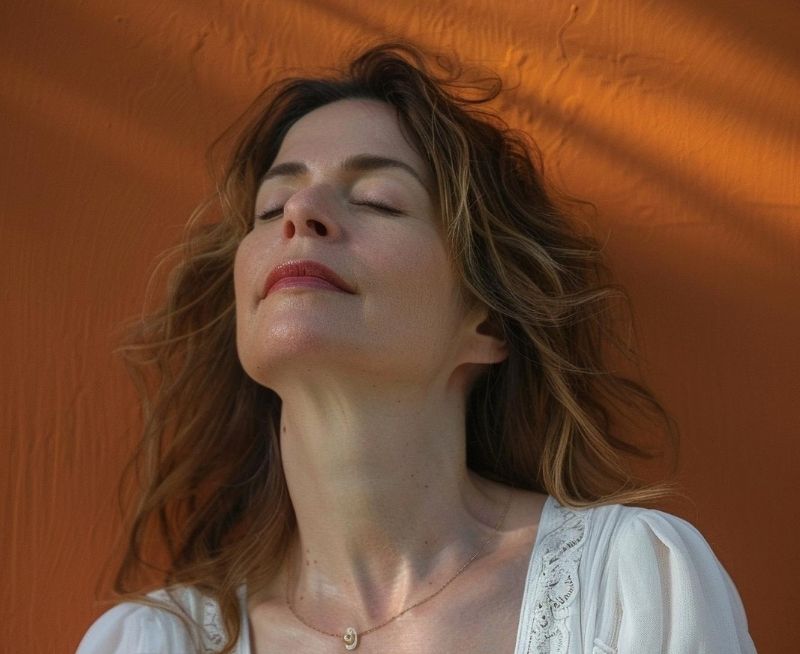 Mujer con ojos cerrados respirando en un momento de pausa y bienestar en Ellas en Armonía