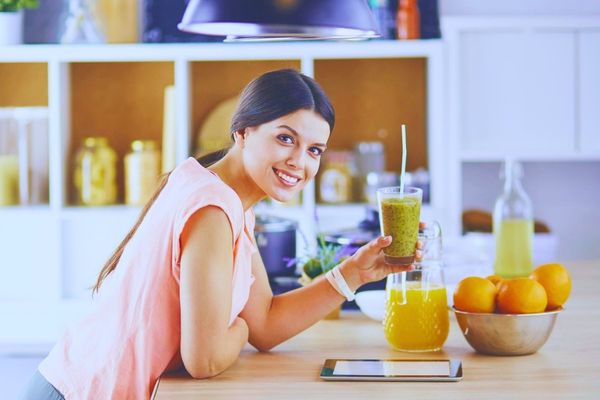 Mujer preparando un jugo natural como parte de hábitos de bienestar femenino en Ellas en Armonía