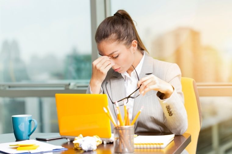 Mujer sintiéndose mentalmente agotada mientras trabaja, representando cansancio emocional y necesidad de calma natural