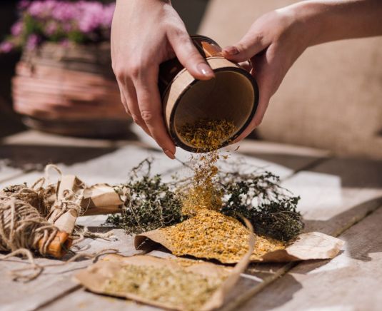 Autocuidado consciente y herbolaria para bienestar Manos preparando ingredientes naturales como parte de una rutina de herbolaria para bienestar y autocuidado consciente