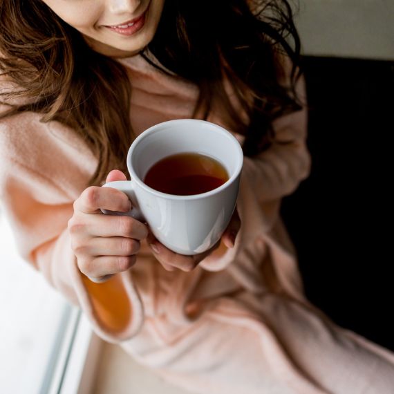 Autocuidado y herbolaria para bienestar Mujer sosteniendo una taza de té en un momento de autocuidado y herbolaria para bienestar