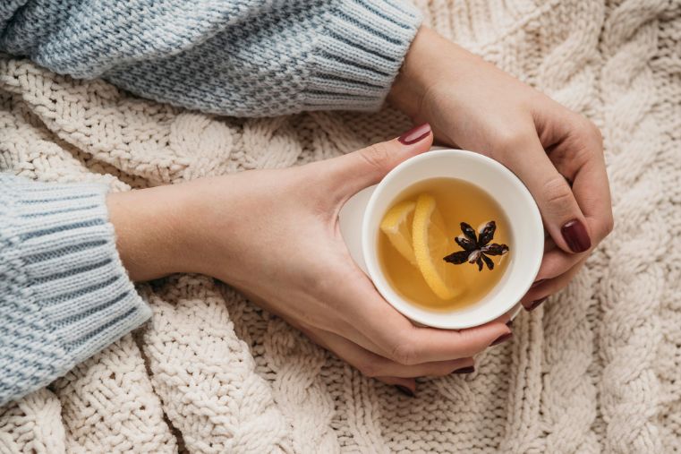 Manos sosteniendo una infusión caliente como símbolo de calma, bienestar emocional y autocuidado consciente